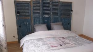 a bed in a room with a wooden wall at Le Jardinet in Pont-Sainte-Maxence