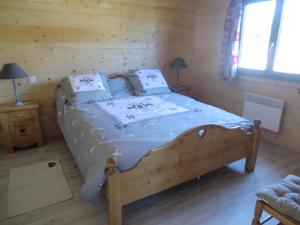 1 dormitorio con 1 cama en una cabaña de madera en Chalet Flocon, en Plénise