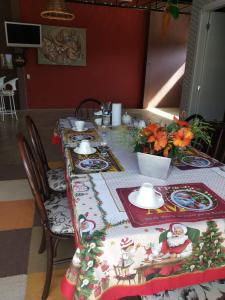 uma mesa de jantar com uma toalha de mesa temática de Natal em Gastaldon Suite em Chapecó
