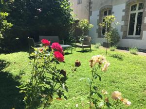 a garden with flowers and a table and chairs at Tourisme et Affaires Quimper + parking privé, wifi, jardin in Quimper