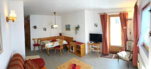 a living room with a table and a dining room at Sportlerzimmer & Apartments in Celerina