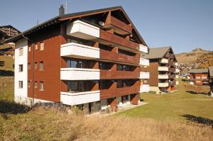 an apartment building with balconies on top of a hill at Alpenhaus Bettmeralp in Bettmeralp