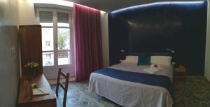 una camera da letto con letto con testiera blu e finestra di Casa Orrù a Nuoro