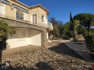 a house with a balcony and a palm tree at Meublé tourisme 4*, les pieds dans l'eau, Villa LAS PALMERAS in La Londe-les-Maures
