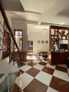 a living room with a checkered floor and stairs at RiverView HomeStay in Dong Hoi