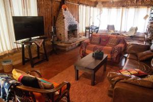 a living room with a couch and a fireplace at Pousada Aruana in Cavalcante