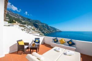 balcone con mobili bianchi e vista sull'oceano. di La Casa di Peppe Guest House & Villa a Positano