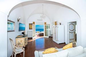 a living room with a white couch and a refrigerator at La Casa di Peppe Guest House & Villa in Positano