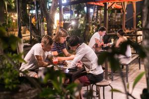 a group of people sitting at tables in a restaurant at Melody Guest House in Jimbaran