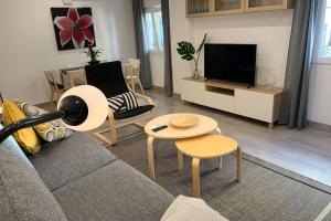 uma sala de estar com um sofá e uma televisão em RENOVATED HOUSE IN OLD TOWN MARBELLA. em Marbella