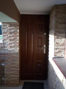a wooden door in a hallway with a brick wall at Noclegi u Marcela in Ustrzyki Dolne