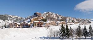 un lodge en la nieve en una montaña en Appartamenti i Portici, en Prato Nevoso