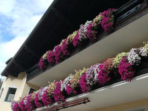 a balcony filled with flowers on a building at Pichlgut in Radstadt