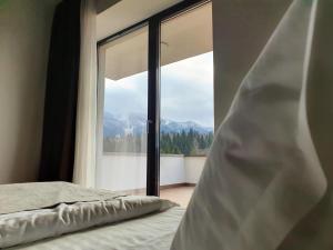 a bedroom with a bed and a large window at Silver Fox Residence in Poiana Brasov +26 photos