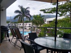 balcón con mesa, sillas y piscina en Apartasol en Santa Fe de Antioquia Apartment, en Santa Fe de Antioquia