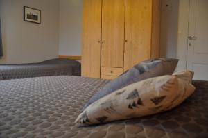 een slaapkamer met een bed met 2 kussens erop bij Les Terriers Saint-Hubert in Hatrival