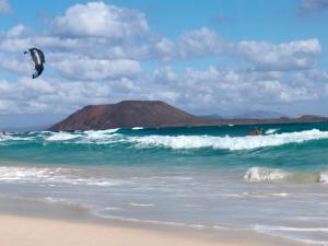 a person is flying a kite on the beach at Villa Shepherd Lajares - LUXURY VILLA FUERTEVENTURA in Lajares