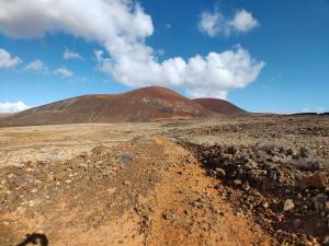 a mountain in the middle of a dirt field at Villa Shepherd Lajares - LUXURY VILLA FUERTEVENTURA in Lajares
