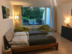 two beds in a room with a large window at Apartment Harzgrün 2 in Sankt Andreasberg