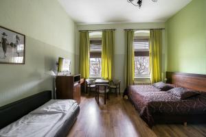 a bedroom with a bed, desk, chair and window at Pension Classic in Berlin