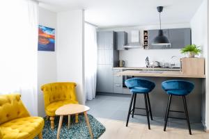 a kitchen with blue chairs and a kitchen counter at Dreamy Garden Zagreb in Zagreb