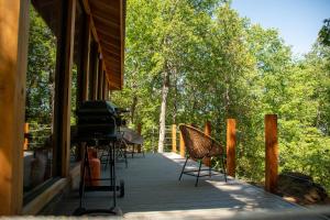 - une terrasse couverte avec des chaises et un barbecue dans une maison dans l'établissement Cabaña Chucao, à Conguillio