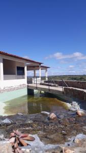 特里溫福的住宿－Pousada Pedra do Sossego，水体上方有桥的房子