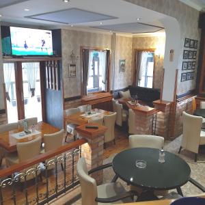 a restaurant with tables and chairs and a flat screen tv at Guest House Bona Fides in Nova Varoš