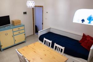 een slaapkamer met een bed, een tafel en een tv bij Amalfi Pool Suite - Puglia Mia Apartments in Monopoli