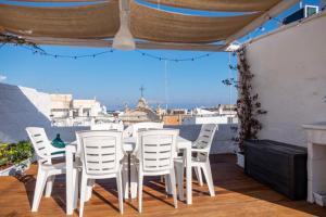 een groep witte stoelen en een tafel op een balkon bij Amalfi Pool Suite - Puglia Mia Apartments in Monopoli