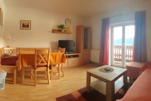a living room with a dining room table and a television at Haus am Hang in Innerschwand am Mondsee