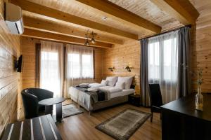 een slaapkamer met een bed in een kamer met houten wanden bij Barrico Thermal Hotel in Demjén