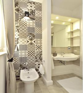 a bathroom with a toilet and a sink and a mirror at URBAN JUNGLE HOME (BORGO RIO FAVARA) in Ispica
