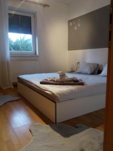 a bedroom with a bed with a stuffed animal on it at Landhaus Tirol in Presseggersee