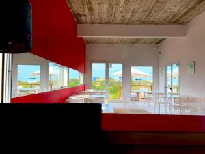 a dining room with tables and chairs and windows at Terrazas de la Viuda in Punta Del Diablo