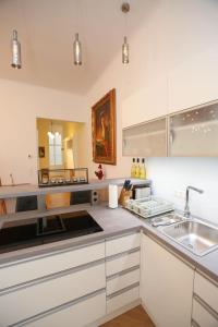 una cocina con armarios blancos y fregadero en Luxusapartment Altes Rathhaus en Viena