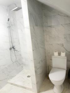 biała łazienka z toaletą i prysznicem w obiekcie Царська гора w mieście Miżhirja