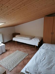 a room with two beds and a wooden ceiling at Izby pod Martiniskými hoľa i v sukromí in Martin