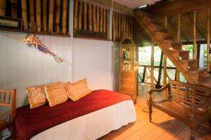 a bedroom with a bed and a wooden staircase at Cocoa Cottage in Roseau
