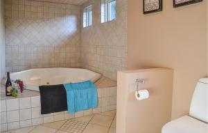 a bathroom with a tub and a toilet at Pet Friendly Home In Ansager With Sauna in Ansager