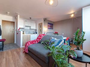 a living room with a couch and a table with plants at Modern studio in the city center of Wroclaw! in Wrocław