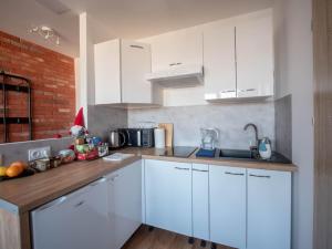a kitchen with white cabinets and a wooden counter top at Modern studio in the city center of Wroclaw! in Wrocław