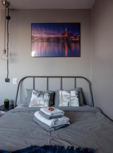 uma cama num quarto com uma fotografia na parede em Modern studio in the city center of Wroclaw! em Breslávia