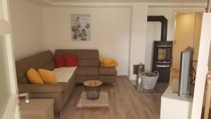 a living room with a couch and a refrigerator at Ferienwohnung Zur Waldkapelle in Nohfelden