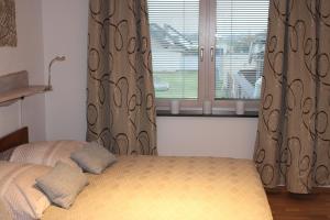 a bedroom with a bed and a window with curtains at Klein-Fein in Euskirchen