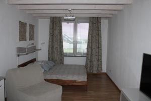 Habitación con cama, sofá y ventana en Klein-Fein en Euskirchen