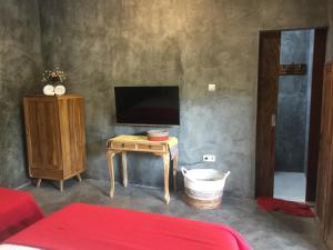 a living room with a tv and a table with a table at Watukarung Ristu Homestay in Kalak