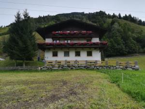 a building with red flowers on top of it at Ferienwohnung Seidl Top 1 in Rauris
