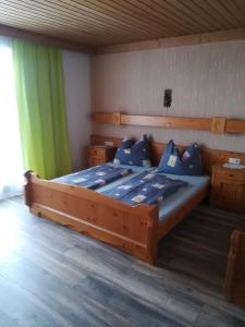 a bedroom with a large wooden bed with blue pillows at Ferienwohnung Seidl Top 1 in Rauris