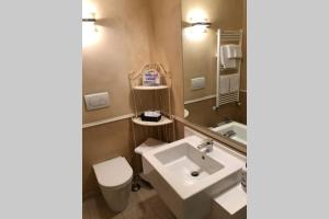 ein Badezimmer mit einem Waschbecken, einem WC und einem Spiegel in der Unterkunft La casina in Burlamacchi in Mailand